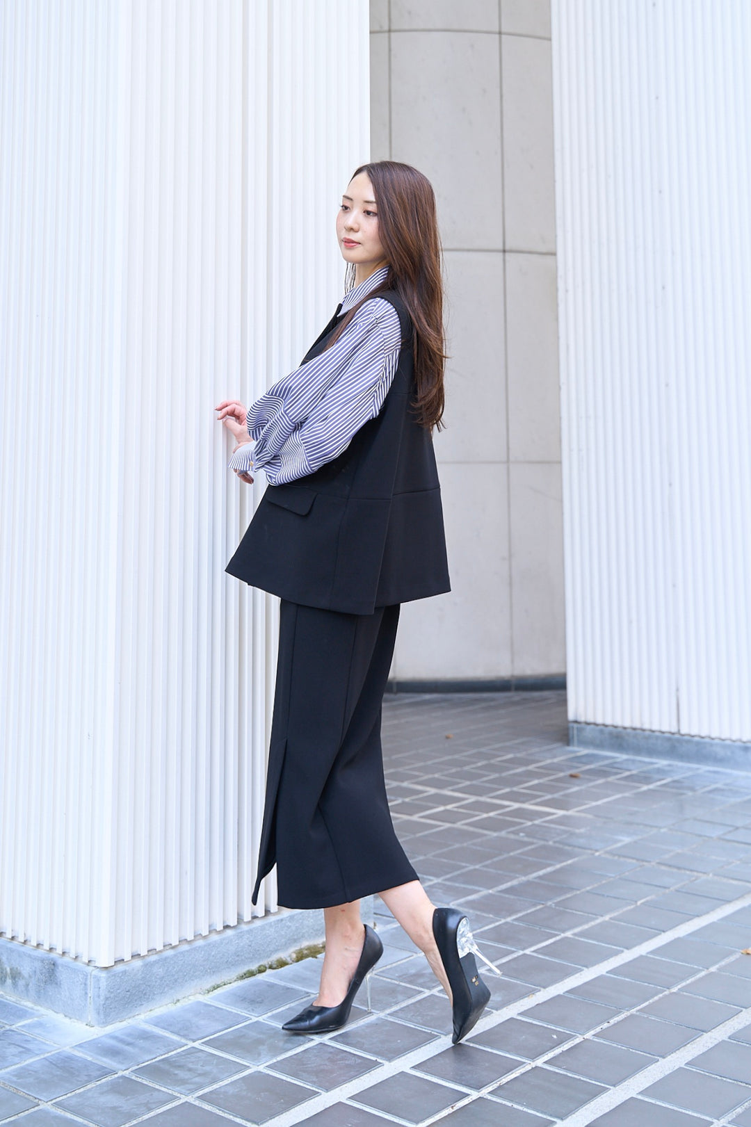 モデルの横向き姿でタイトなシルエットを見せたフロントベントタイトスカート（サイド）