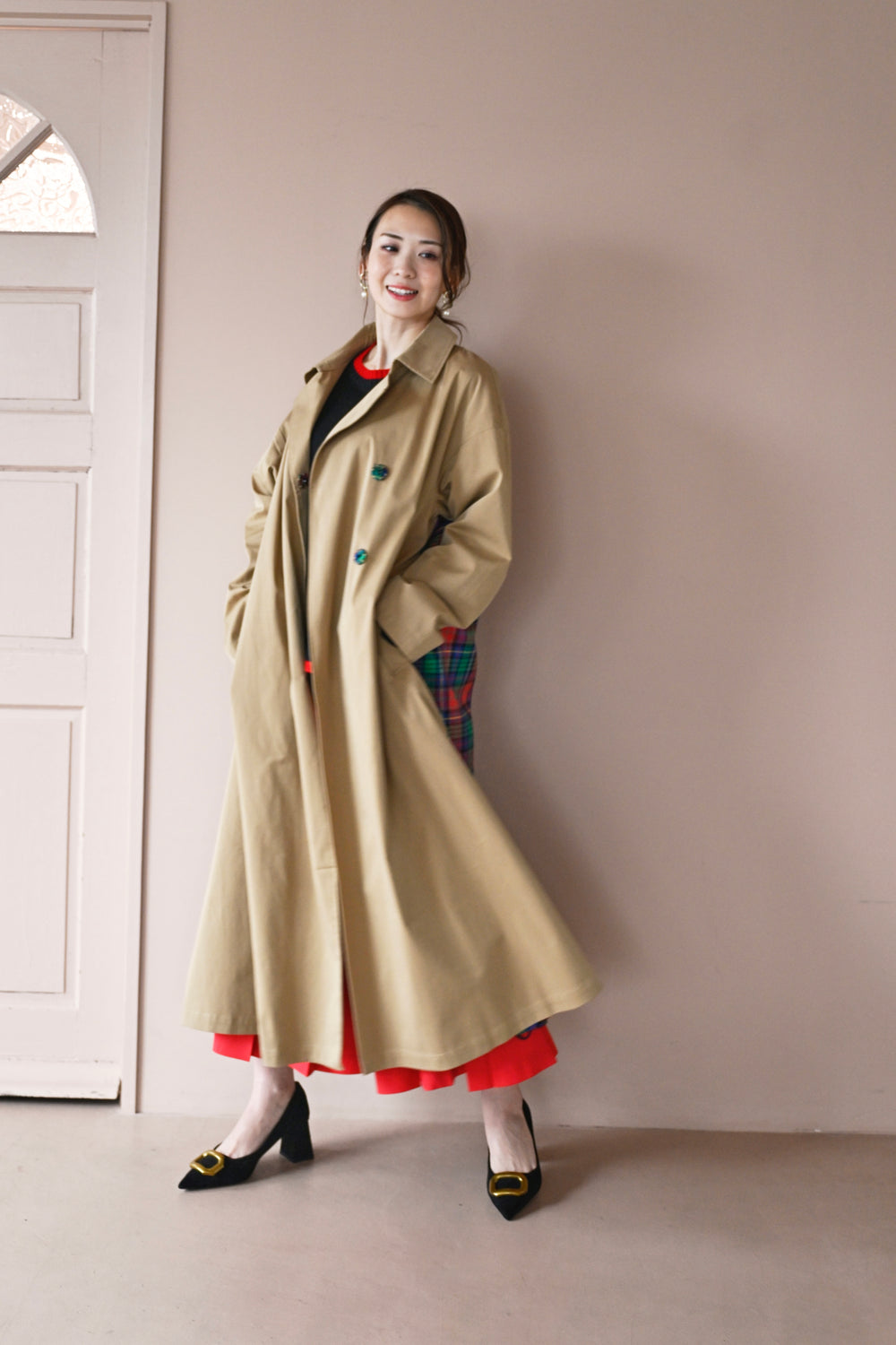 モデルがコートを羽織った前から後ろへのシルエットを見せる着用画像