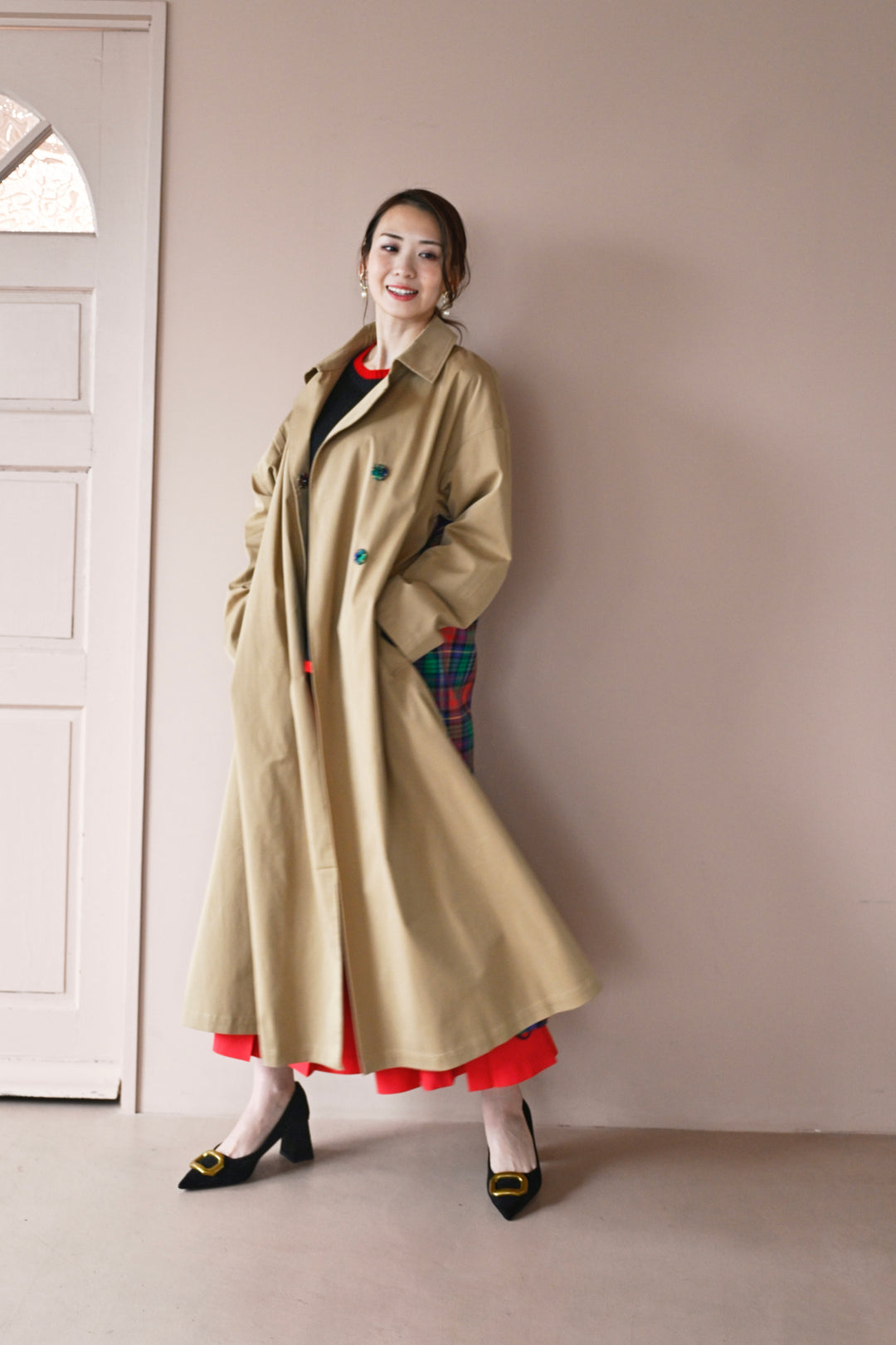 モデルがコートを羽織った前から後ろへのシルエットを見せる着用画像