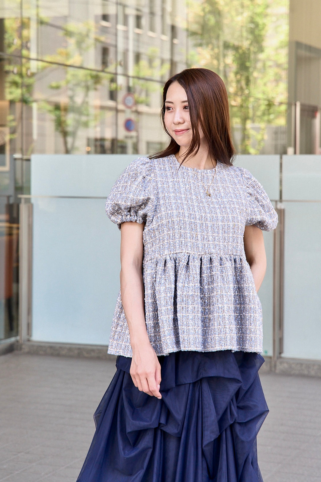モデルが着用した正面スタイルのツイードペプラムトップス